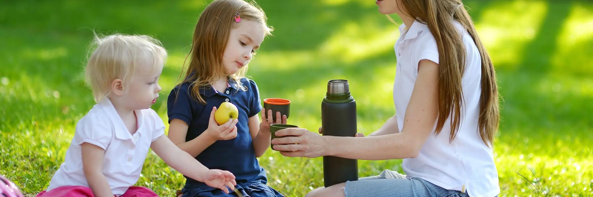Mama z dziećmi na kocu podczas pikniku