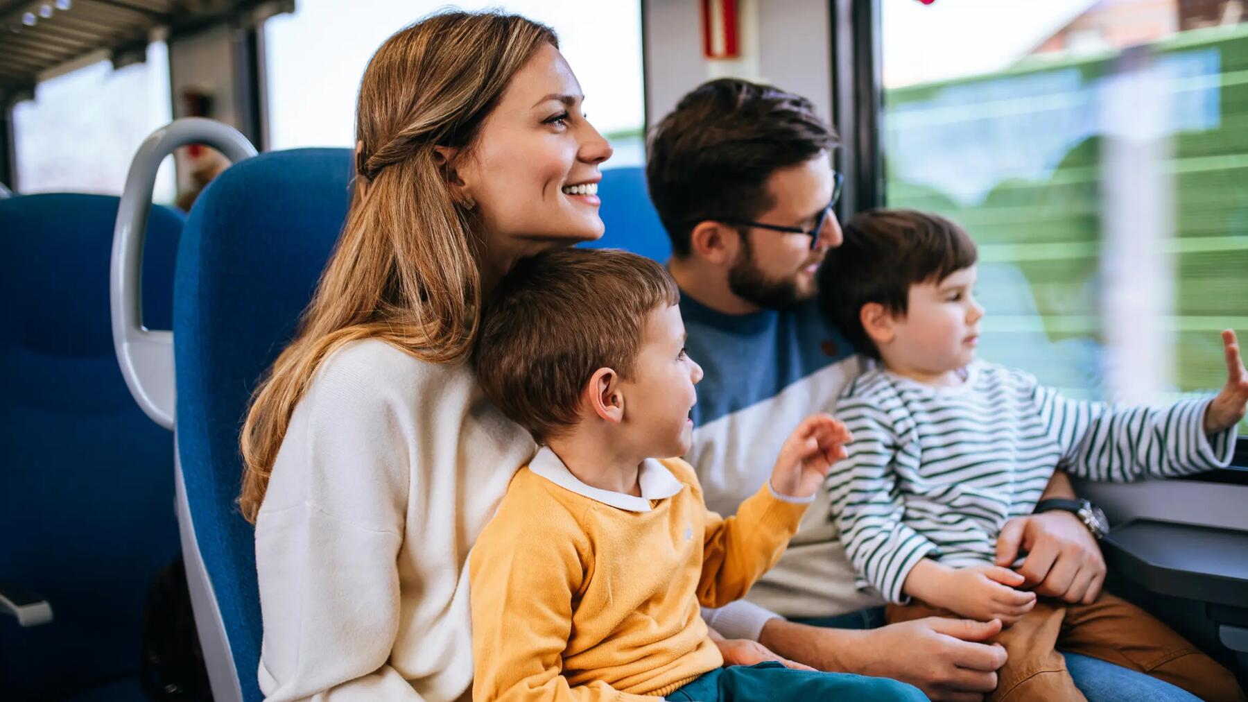 Rodzice z dziećmi na kolanach jadący w pociągu