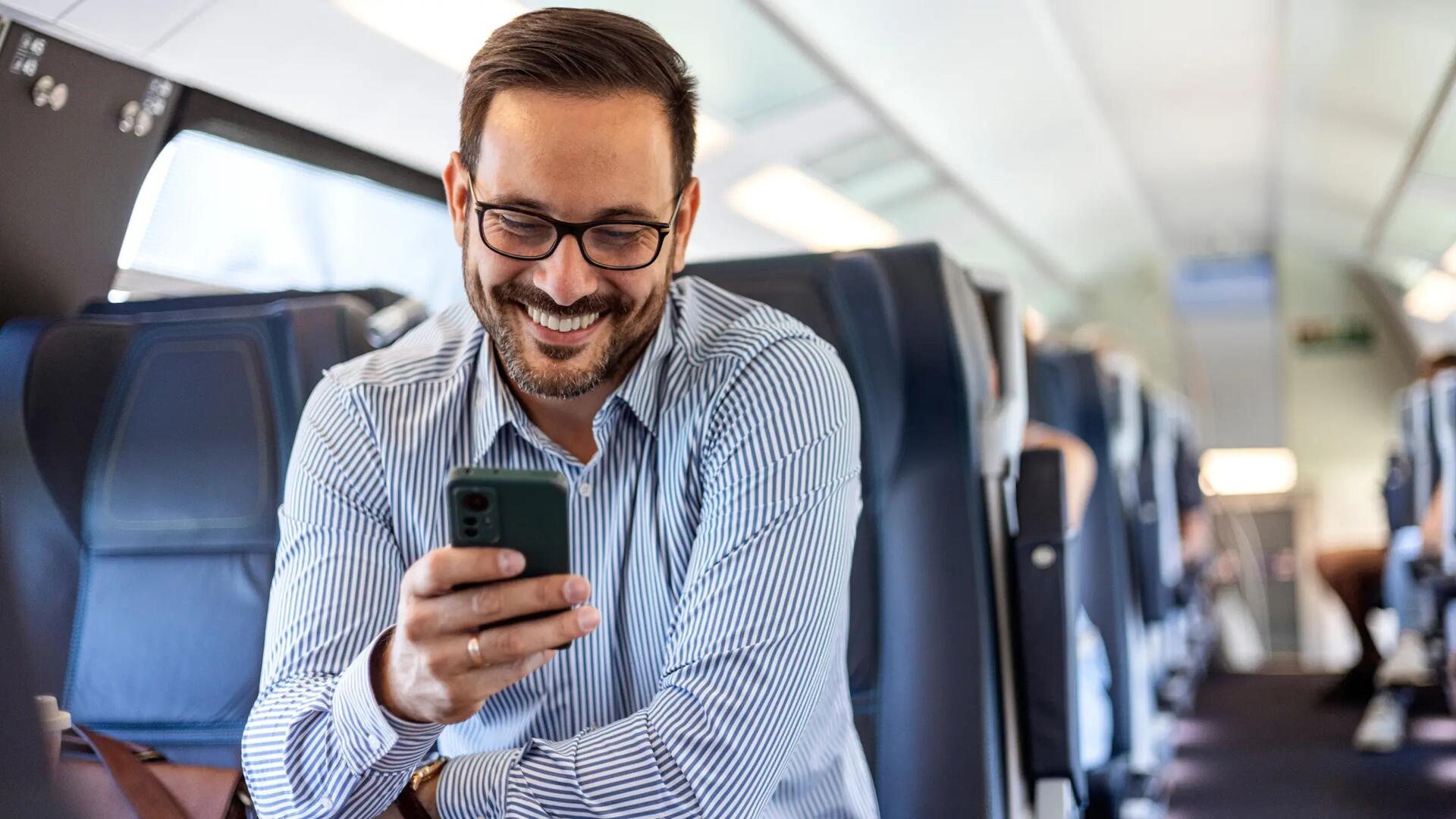 Mężczyzna w pociągu patrzący w telefon