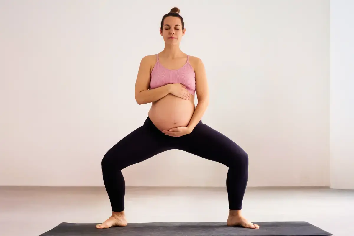 Kobieta w legginsach trenująca pilates w ciąży