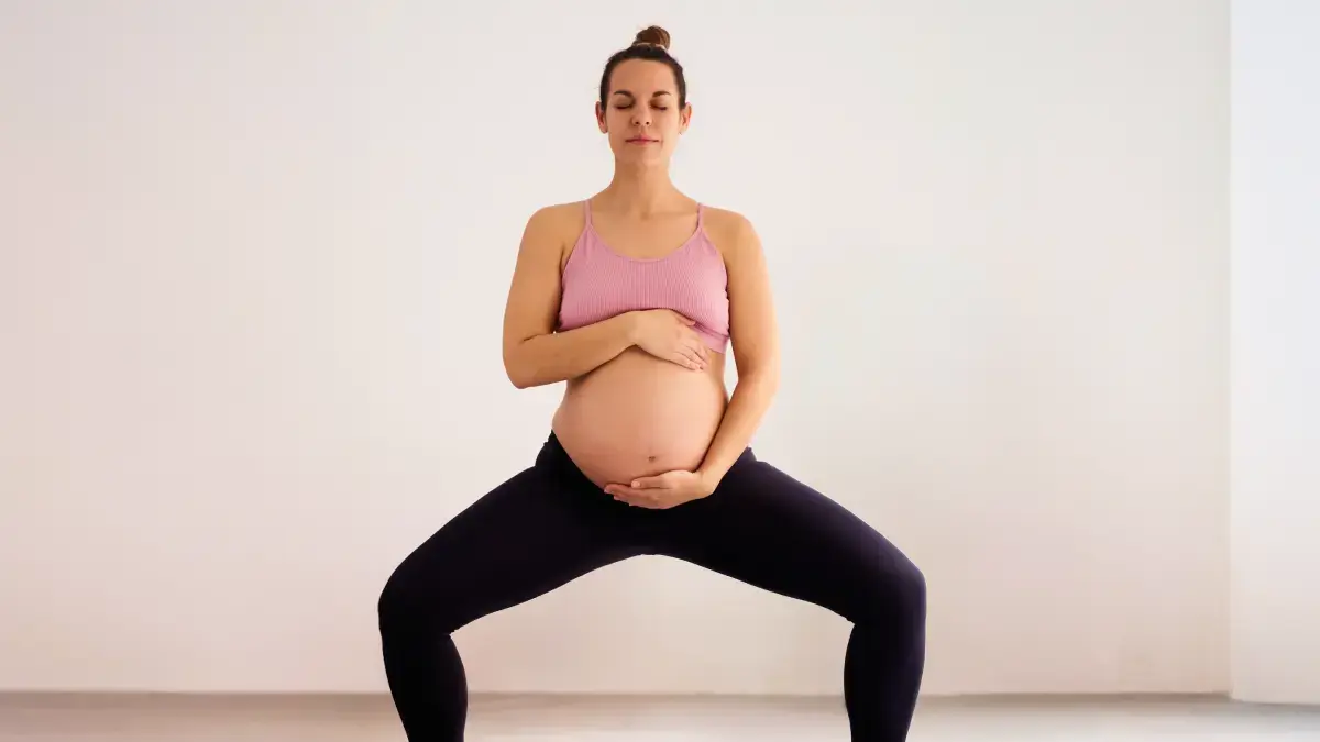Kobieta w legginsach trenująca pilates w ciąży