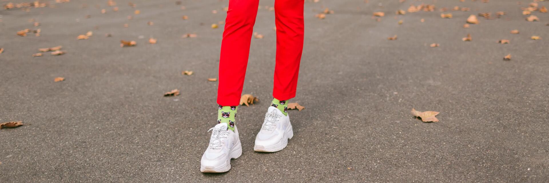Kobieta w sneakersach stojąca na ulicy