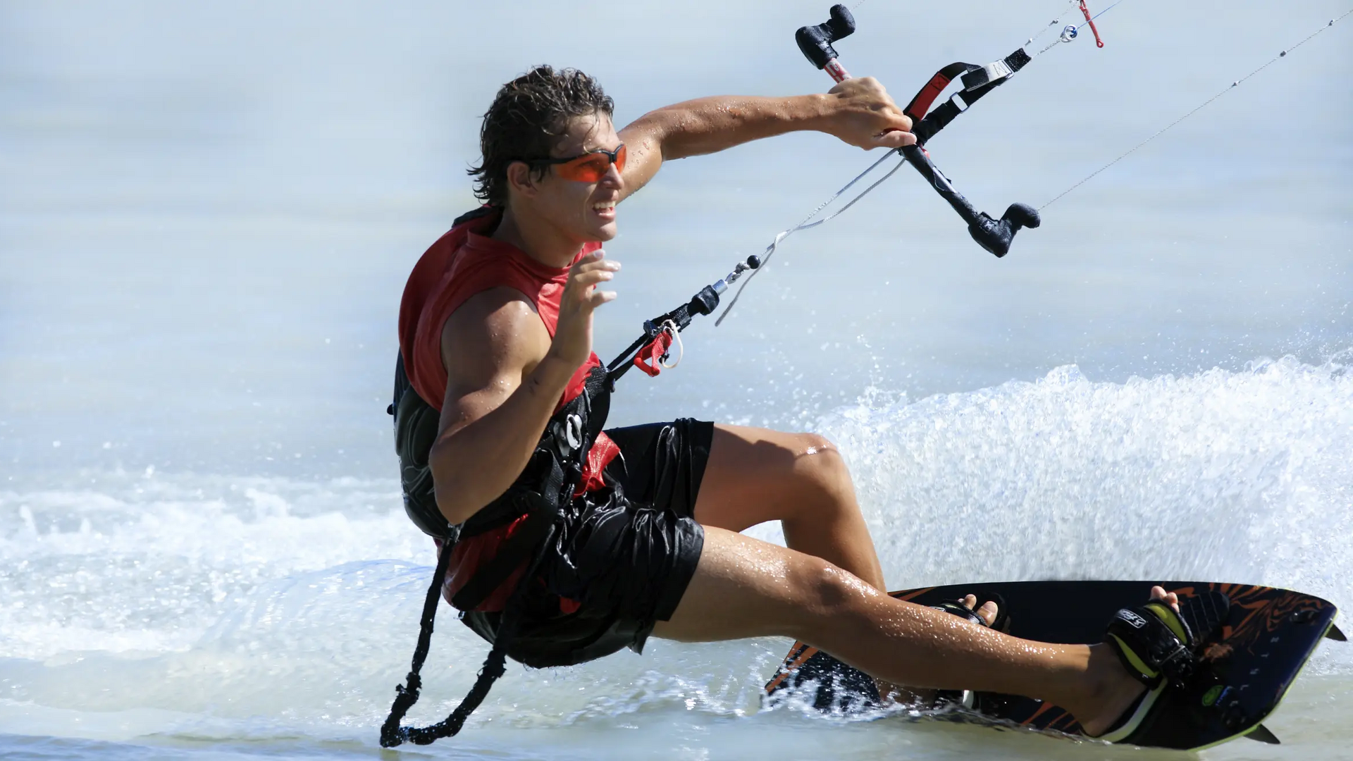 Mężczyzna trenujący na desce kitesurfingowej mający sprzęt ze zrywką bezpieczeństwa