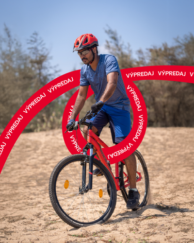 Cyklista na horskom bicykli v teréne s nápisom výpredaj 