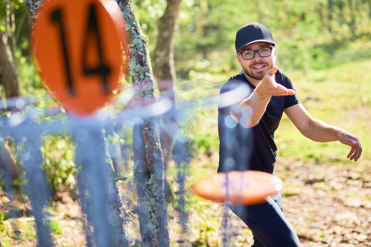 Mężczyzna rzucający dyskiem do kosza