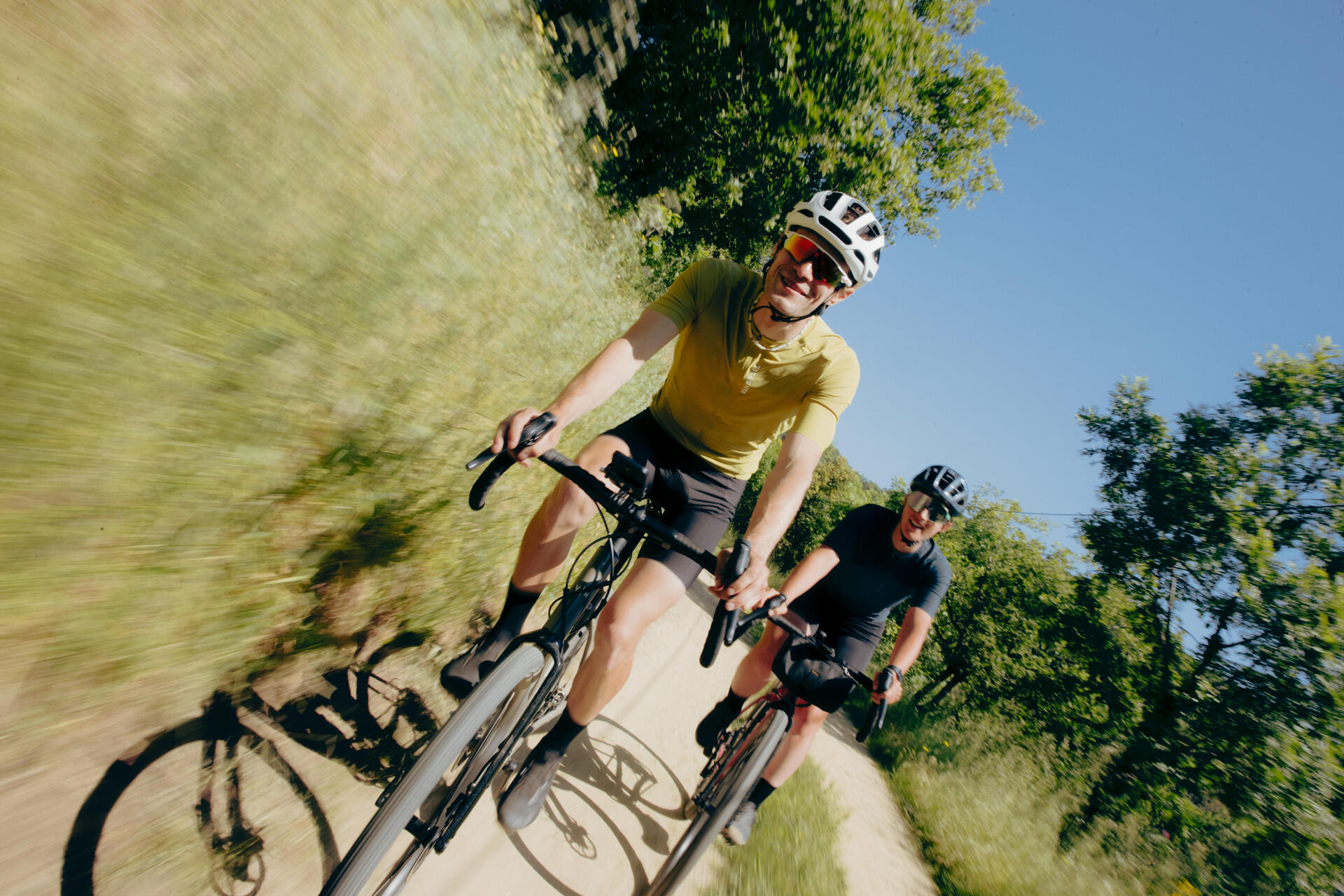 Dwóch rowerzystów w kaskach i w okularach jadący rowerami