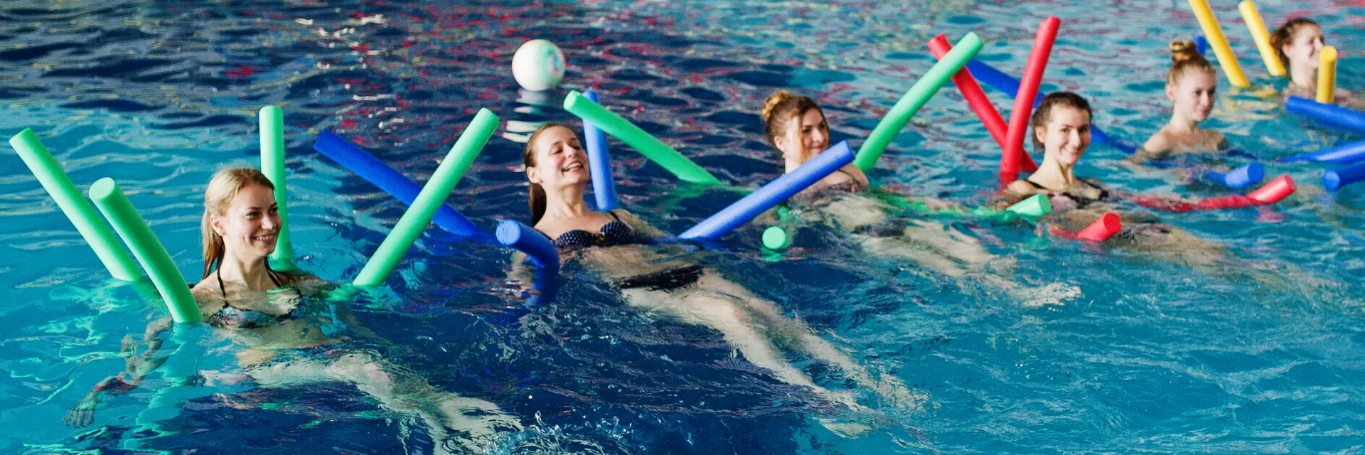 kobiety w strojach kąpielowych trenują aqua aerobik w basenie