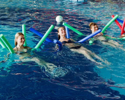 kobiety w strojach kąpielowych trenują aqua aerobik w basenie