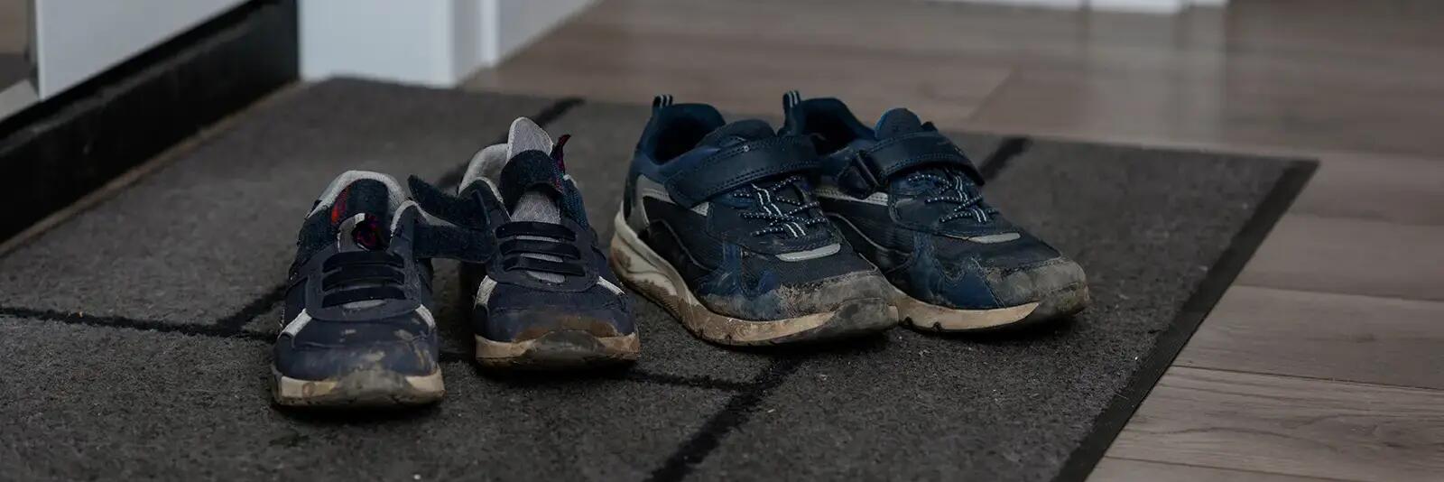 Pobrudzone buty z siatką na wycieraczce