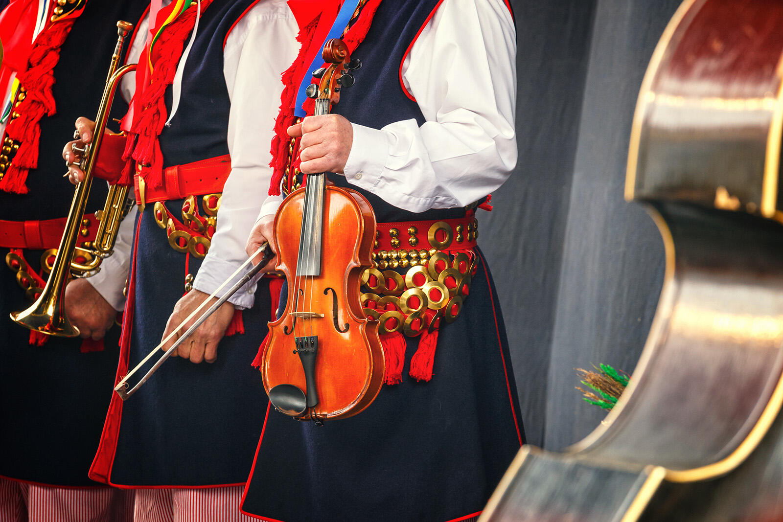 Orkiestra w strojach ludowych trzymająca instrumenty w rękach