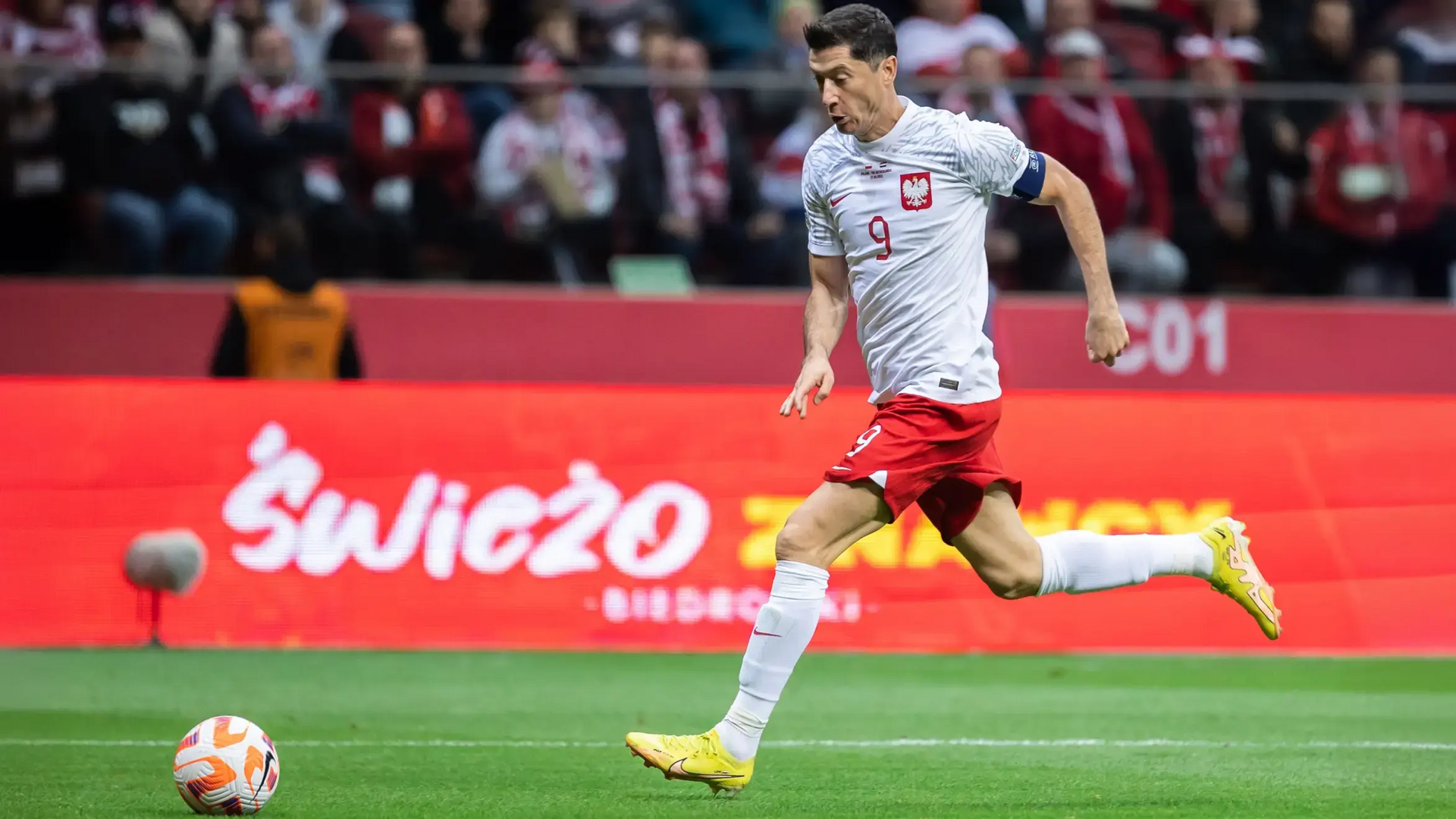 Lewandowski biegnący za piłką na boisku