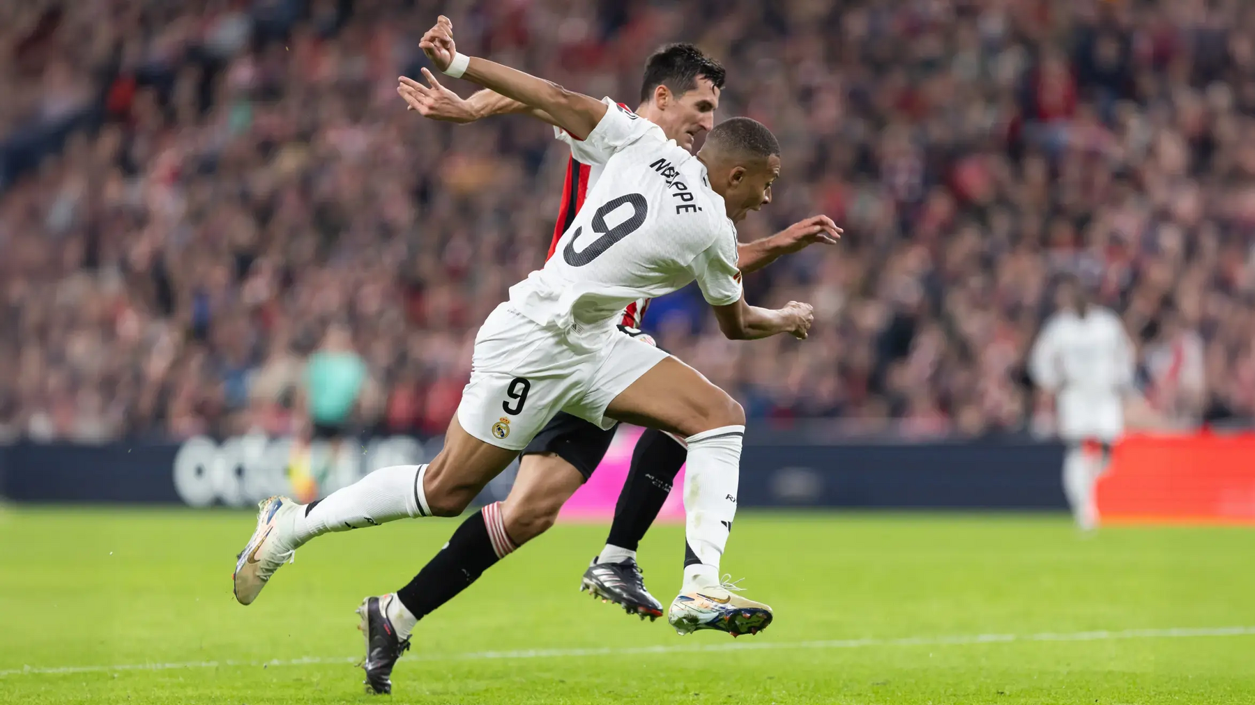 Mbappe z zawodnikiem przeciwnej drużyny biegnący po murawie