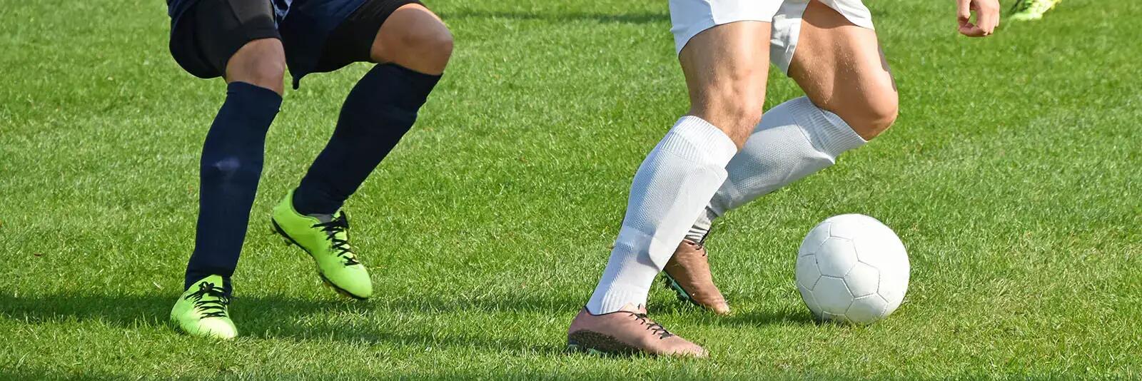 Piłkarze grający w piłkę nożną na boisku