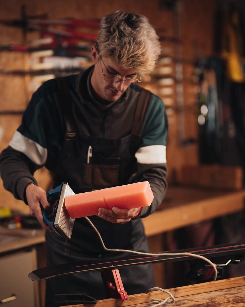 personne qui farte des skis dans un atelier