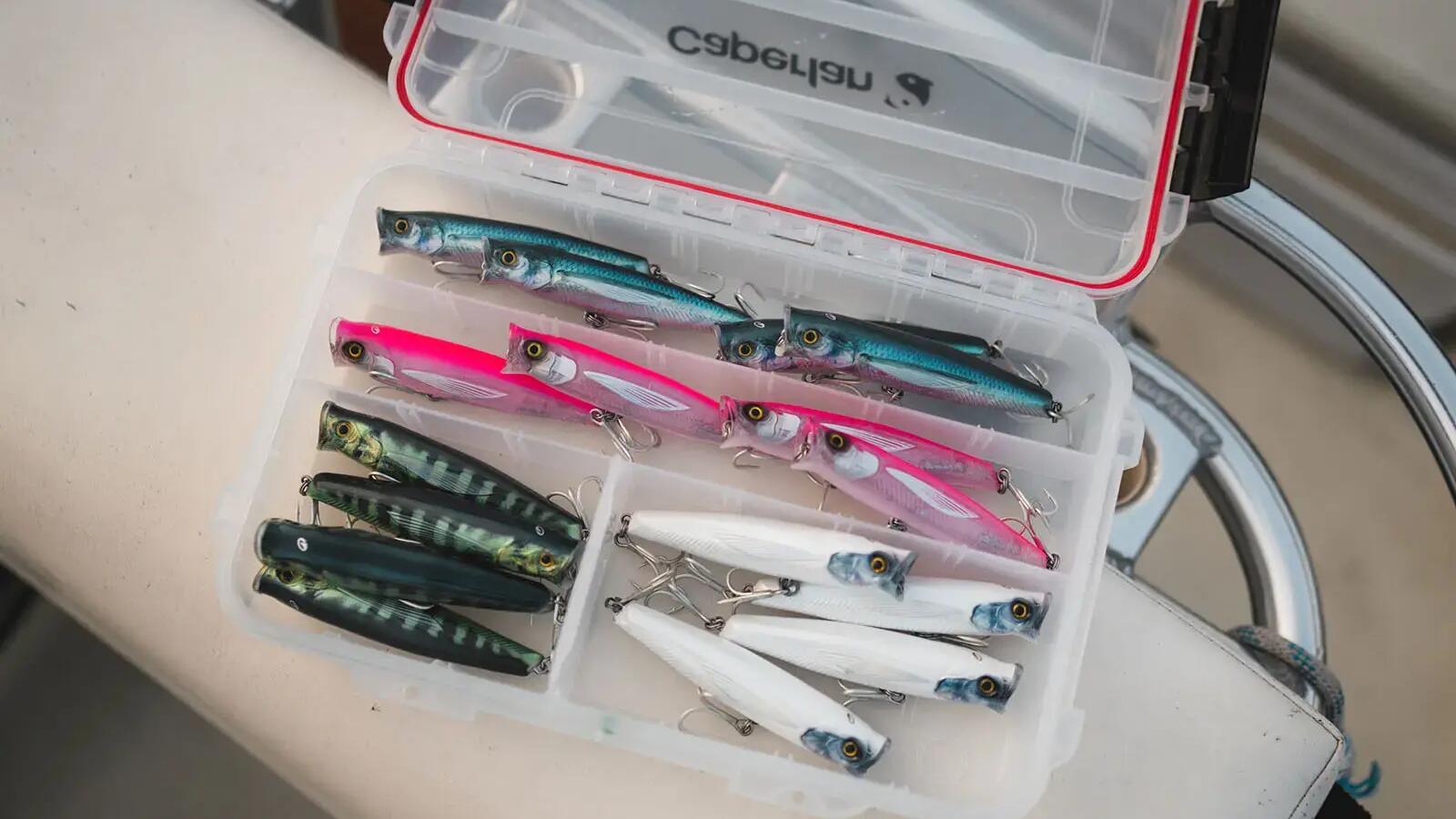 Przynęty na ryby marki Caperlan leżące w plastikowym pudełku z przegrodami