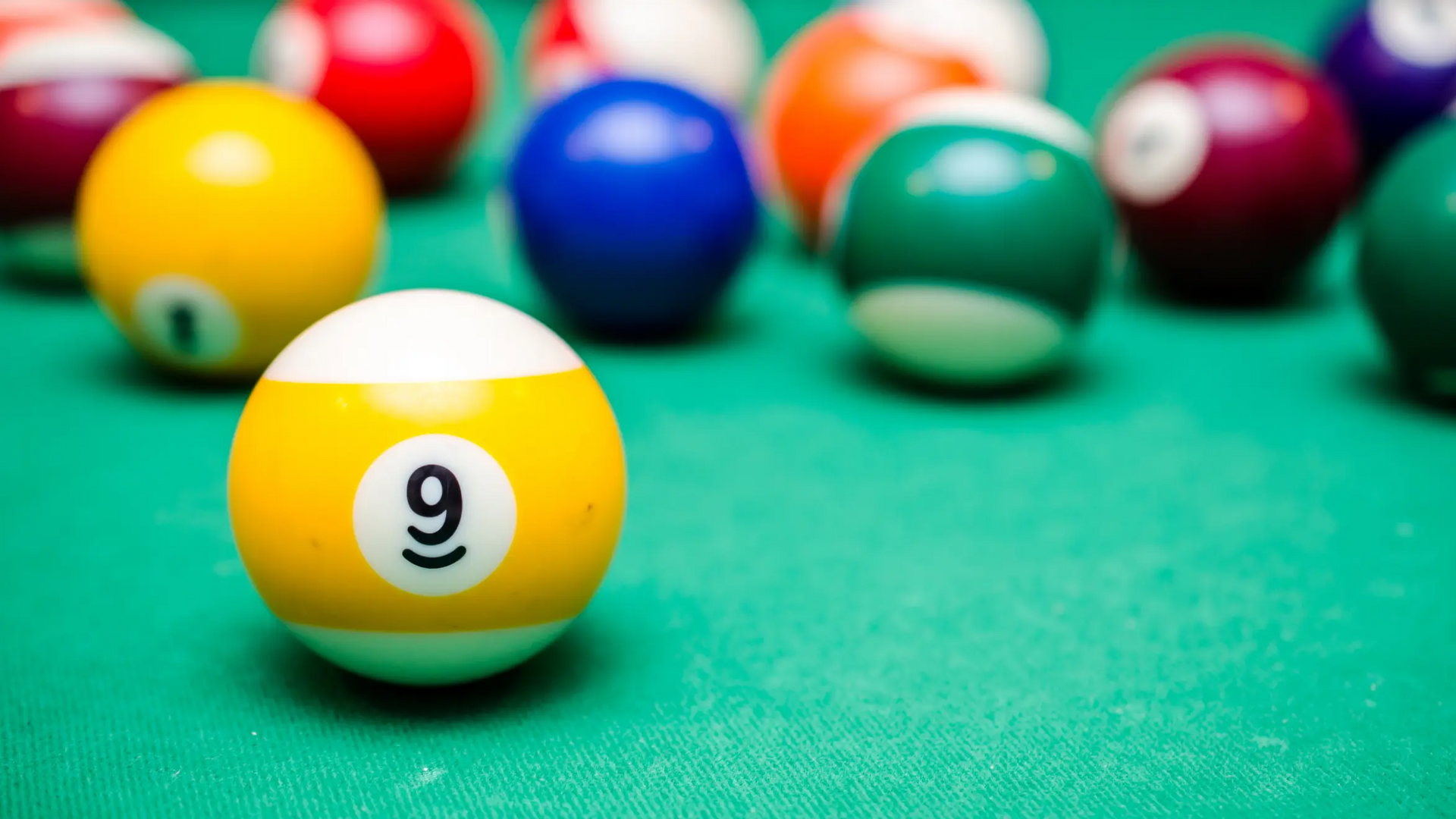 Bile do bilarda przygotowane do gry 9-ball leżące na stole bilardowym