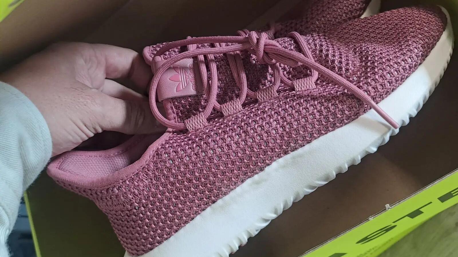 Mężczyzna wkładający sneakersy do kartonu