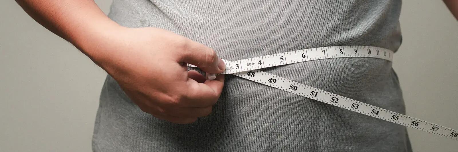 Mężczyzna mierzący obwód brzucha centymetrem