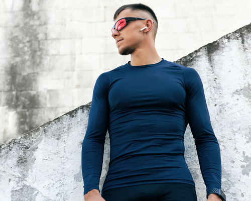 Mężczyzna w longsleeve w okularach i w słuchawkach bezprzewodowych