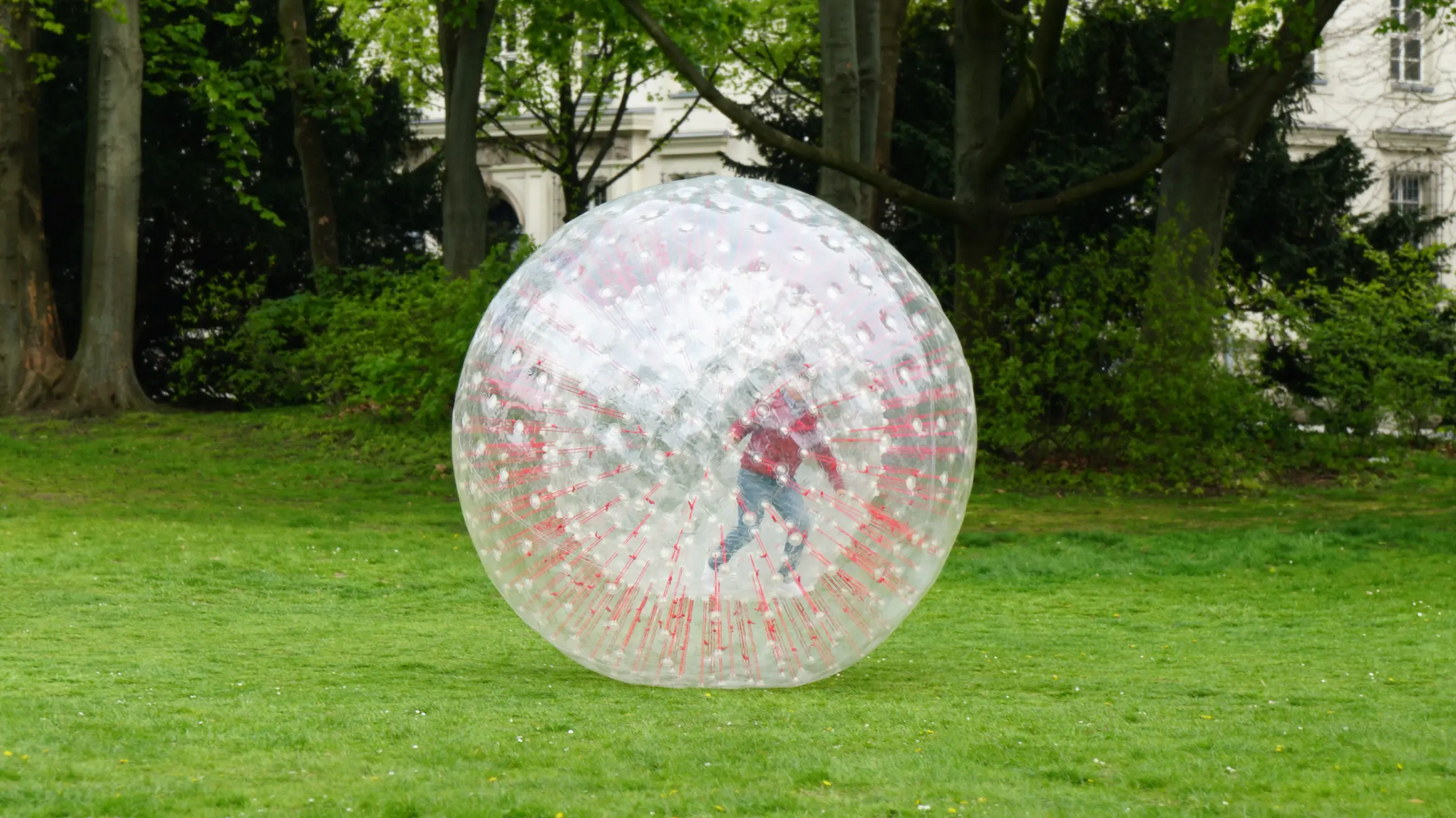 Osoba uprawiająca zorbing na trawie