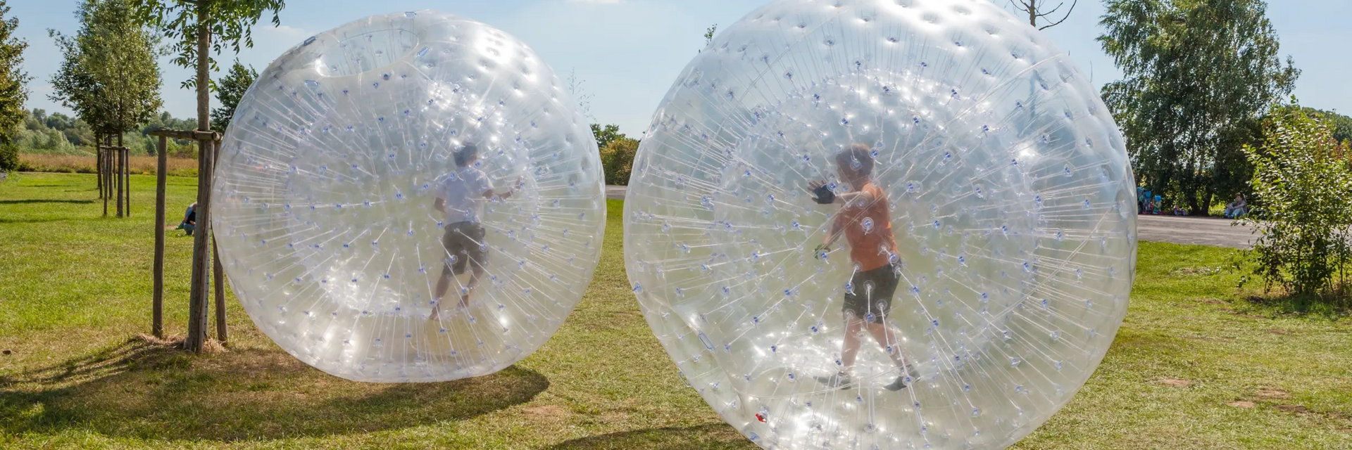 Ludzie uprawiający zorbing na trawie