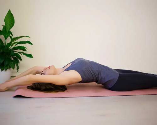 Kobieta leżąca na macie ćwicząca pilates roll up