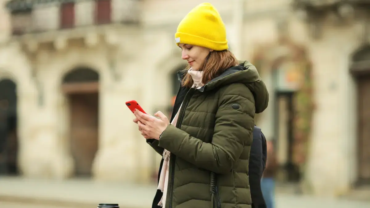 Kobieta patrząca w telefon na ulicy