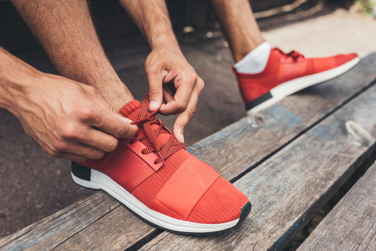 Mężczyzna wiążący sznurówki w adidasach