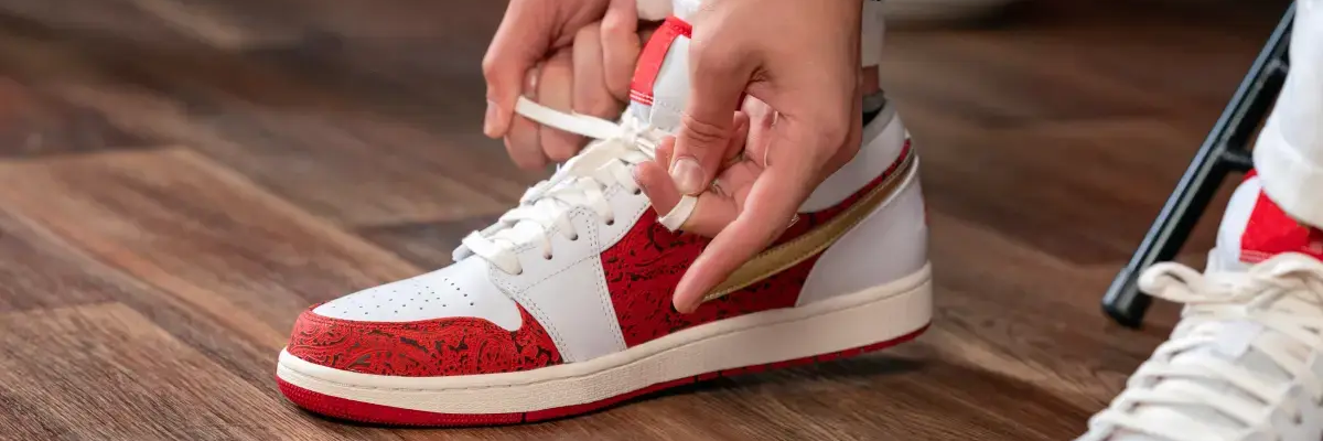Osoba wiążąca sznurówki w sneakersach