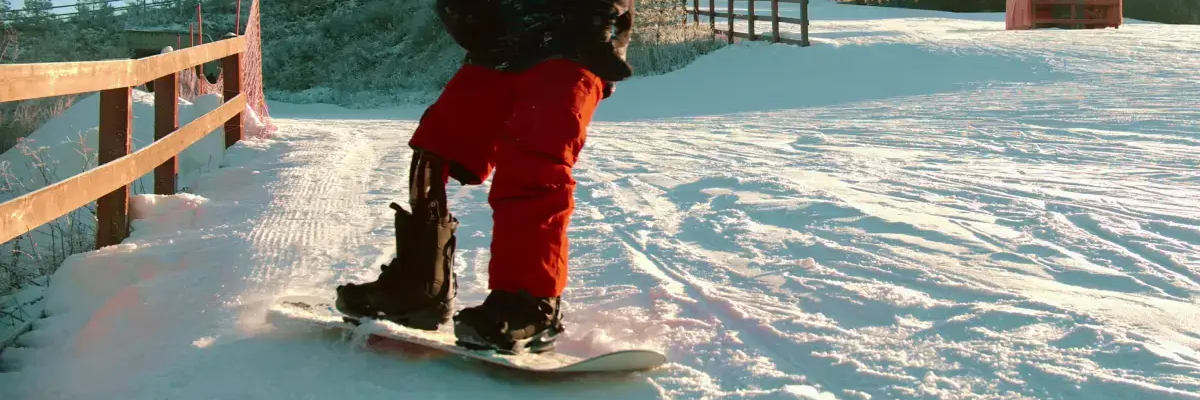 Mężczyzna z protezą nogi jeżdżący na desce snowboardowej