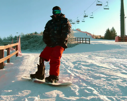 Mężczyzna z protezą nogi jeżdżący na desce snowboardowej