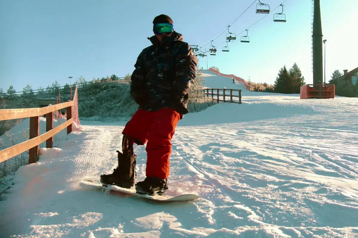 Mężczyzna z protezą nogi jeżdżący na desce snowboardowej