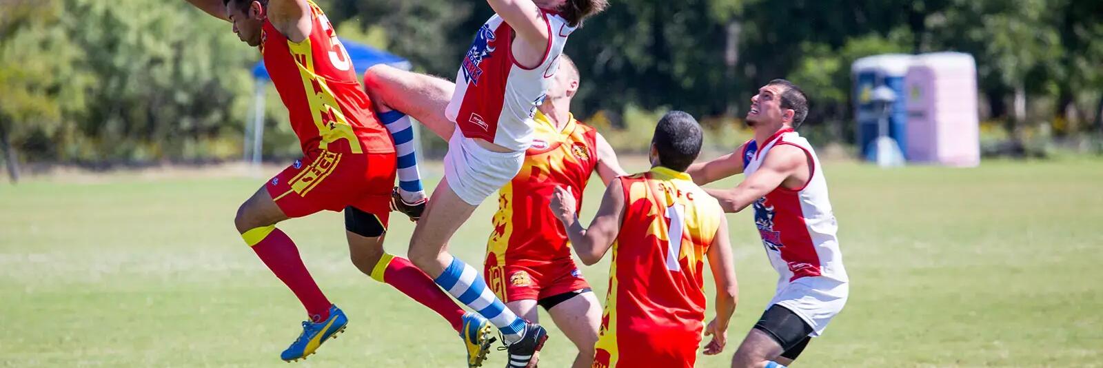 Mężczyźni grający w futbol australijski na boisku