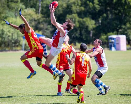 Mężczyźni grający w futbol australijski na boisku