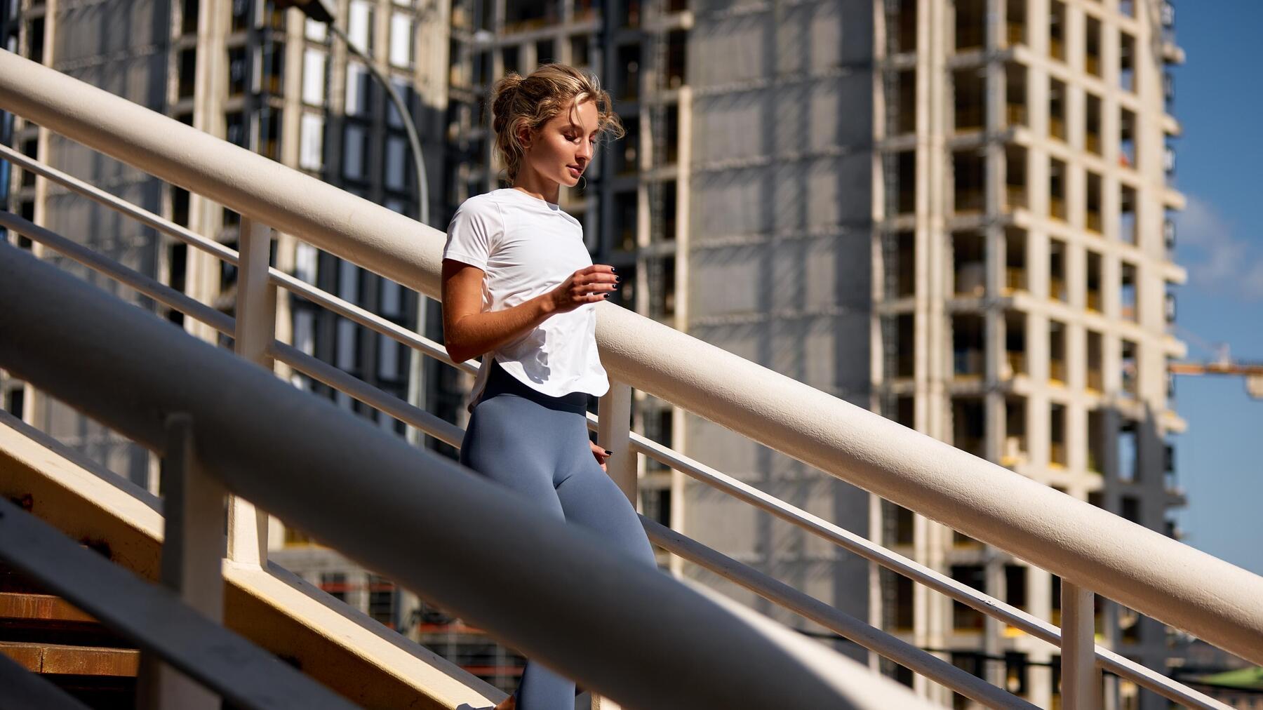 Kobieta ubrana w stylu athleisure schodząca po schodach