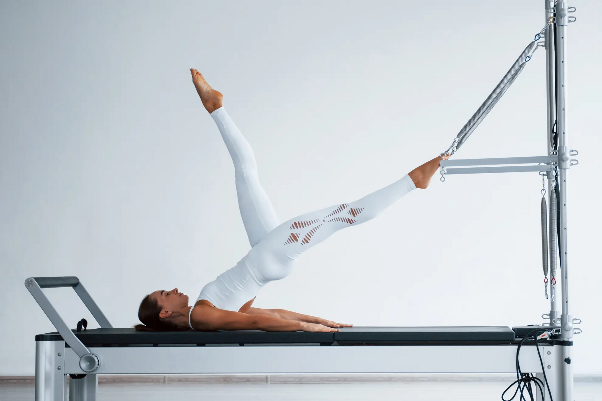 Kobieta ćwicząca pilates tower na reformerze