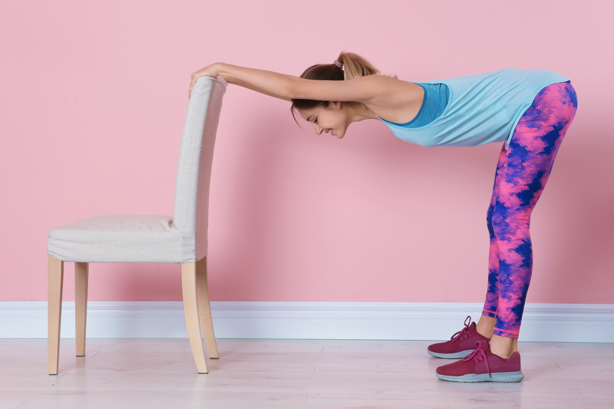 Kobieta ćwicząca pilates przy krześle
