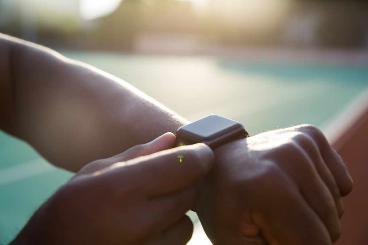 Osoba naciskająca smartwatch na ręku