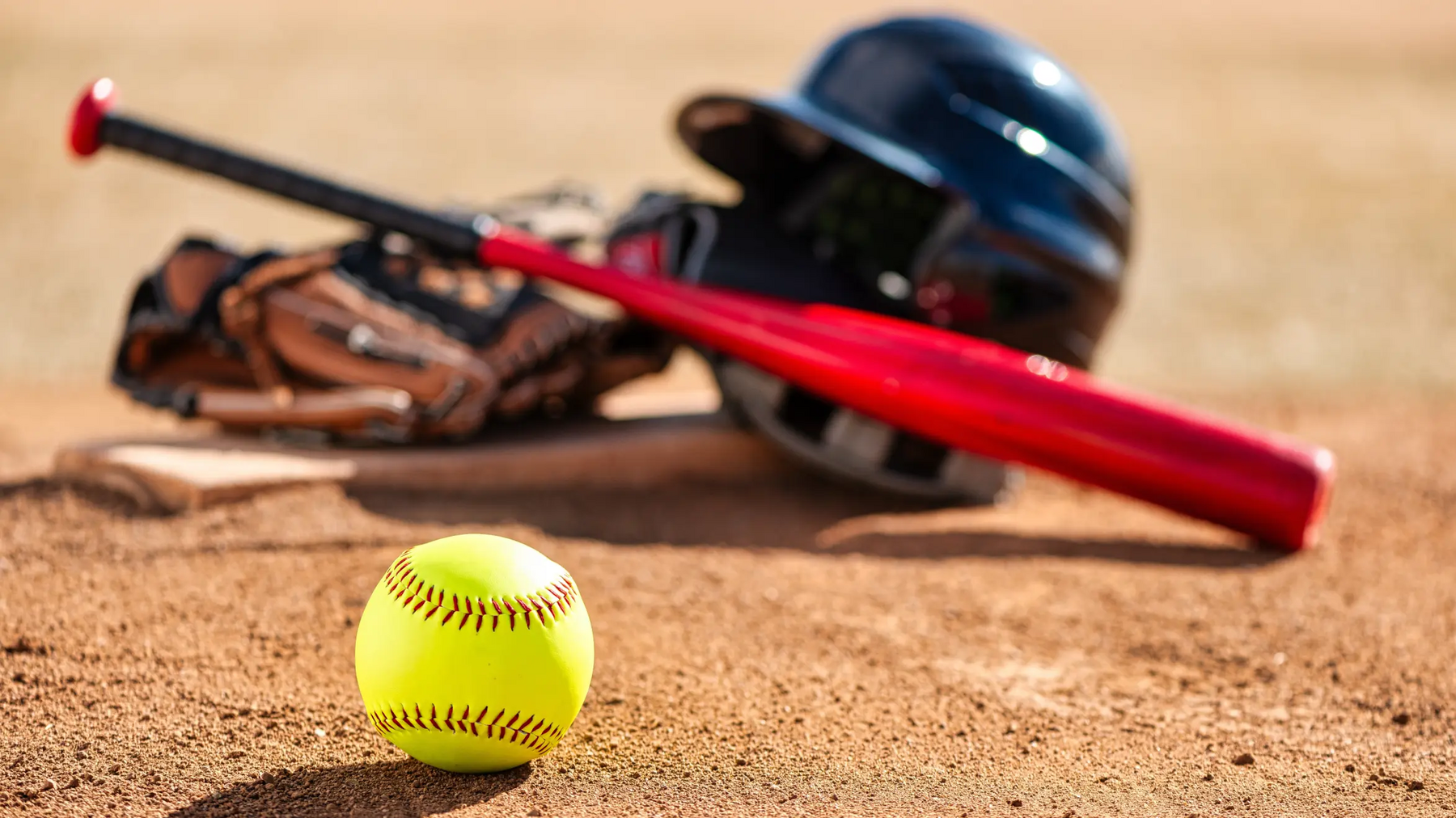 Piłka do softball kij i kask leżące na ziemii