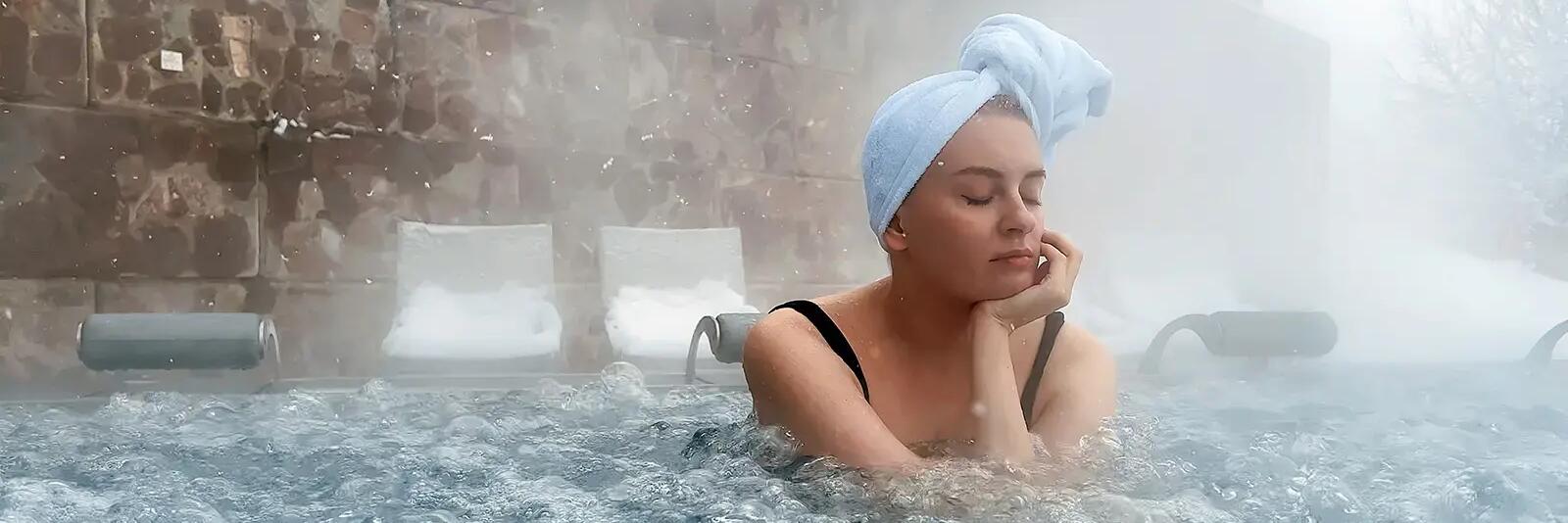 Kobieta z zamkniętymi oczami w turbanie siedząca w termach