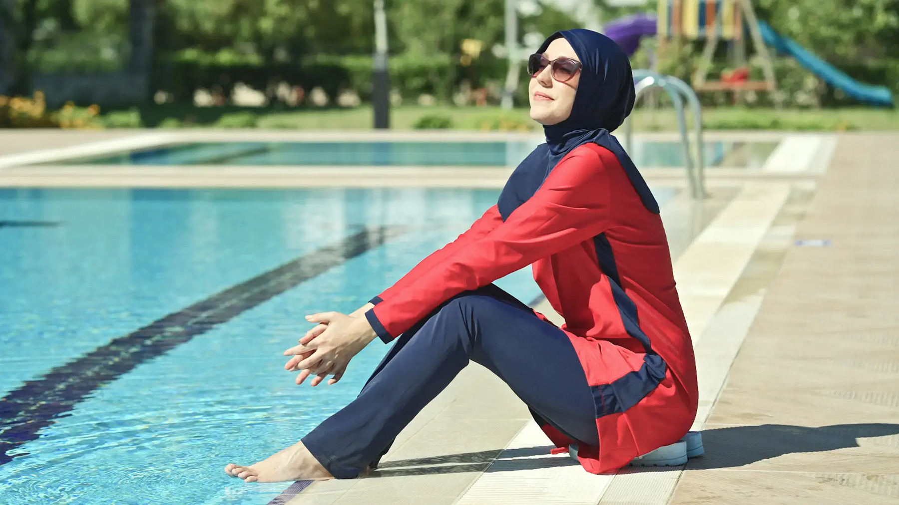 Kobieta siedząca nad basenem w burkini