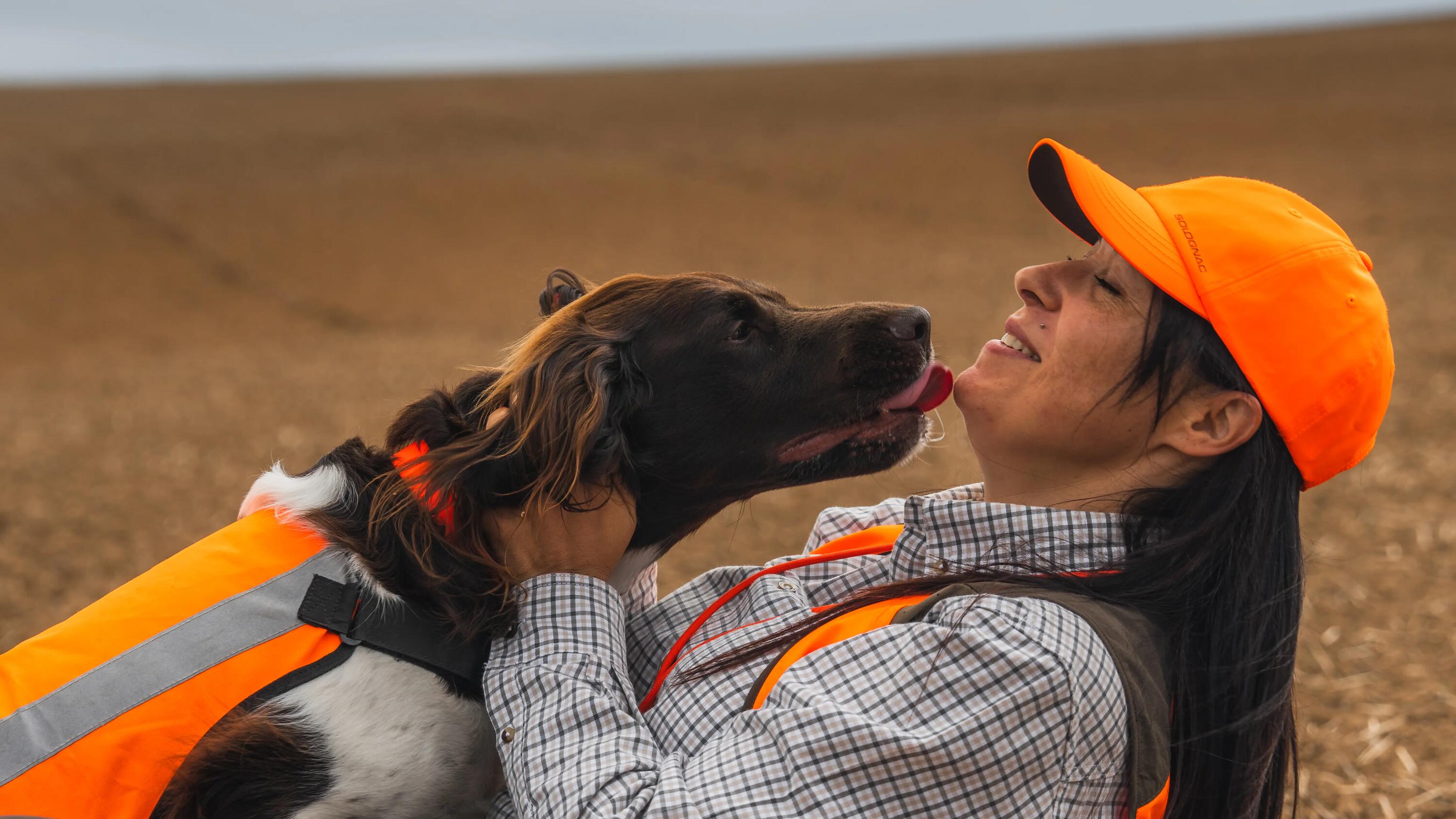 Eine Jägerin wird gerade von ihrem Jagdhund im Gesicht abgeschleckt