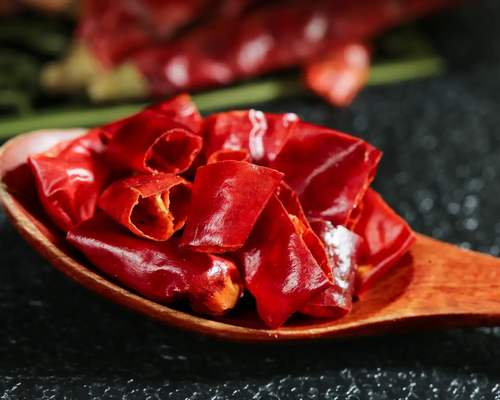 Papryczki chilli w kawałkach leżące na łyżce drewnianej