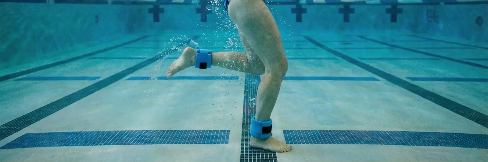 Kobieta trenująca aqua jogging z obciążeniem w basenie