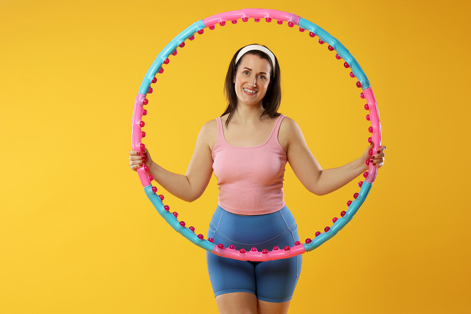 Kobieta trzymająca w rękach hula hop z obciążeniem