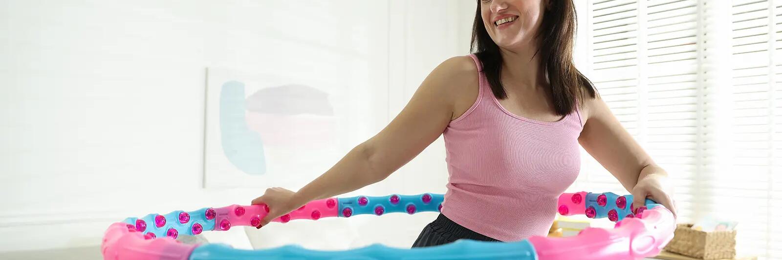 Kobieta kręcąca hula hop z wypustkami w pokoju