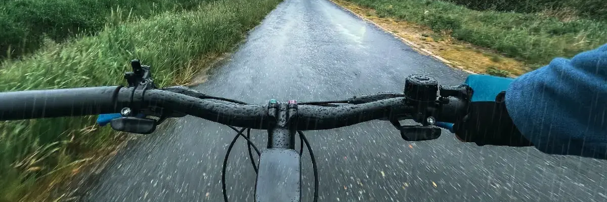 Osoba na rowerze jadąca w burzy
