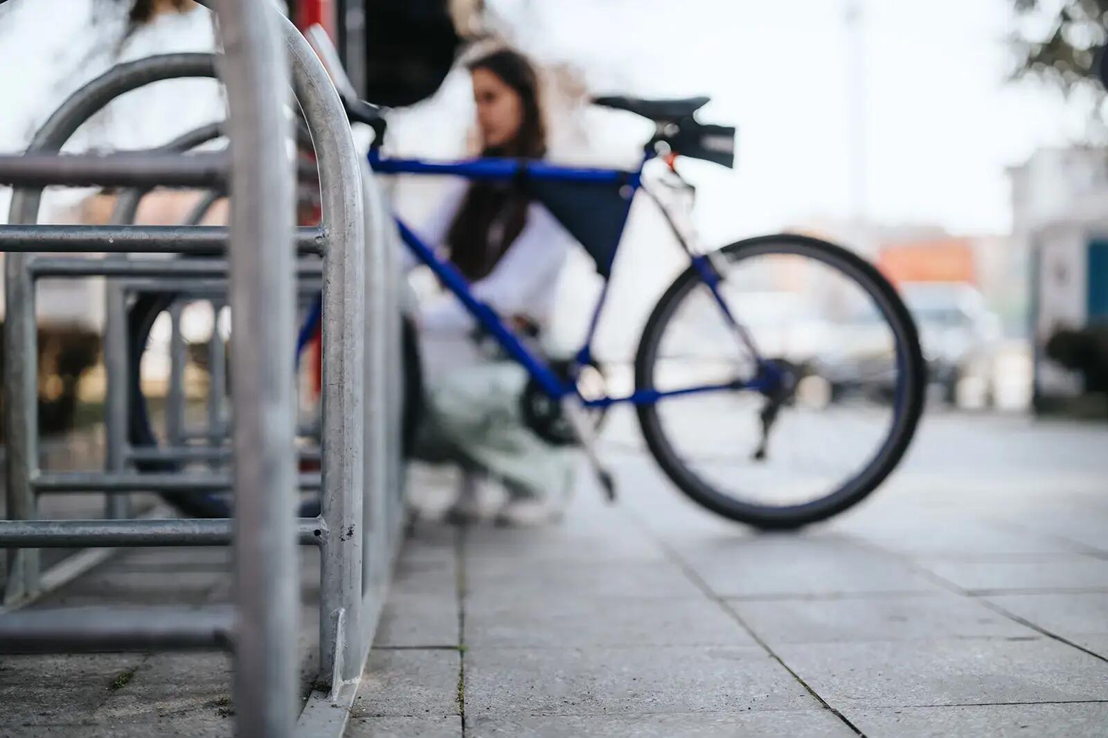Rower przypięty do słupka na parkingu rowerowym