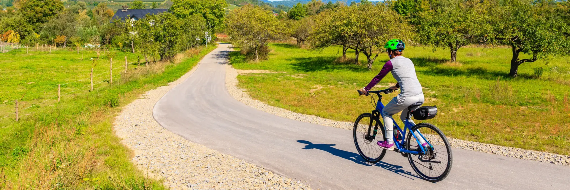 Kobieta w kasku jadąca na rowerze trasą Velo Dunajec