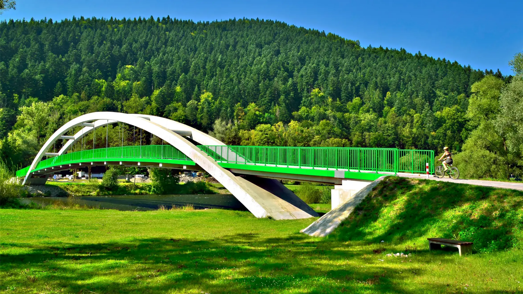 Kobieta w kasku jadąca rowerem po trasie Velo Dunajec